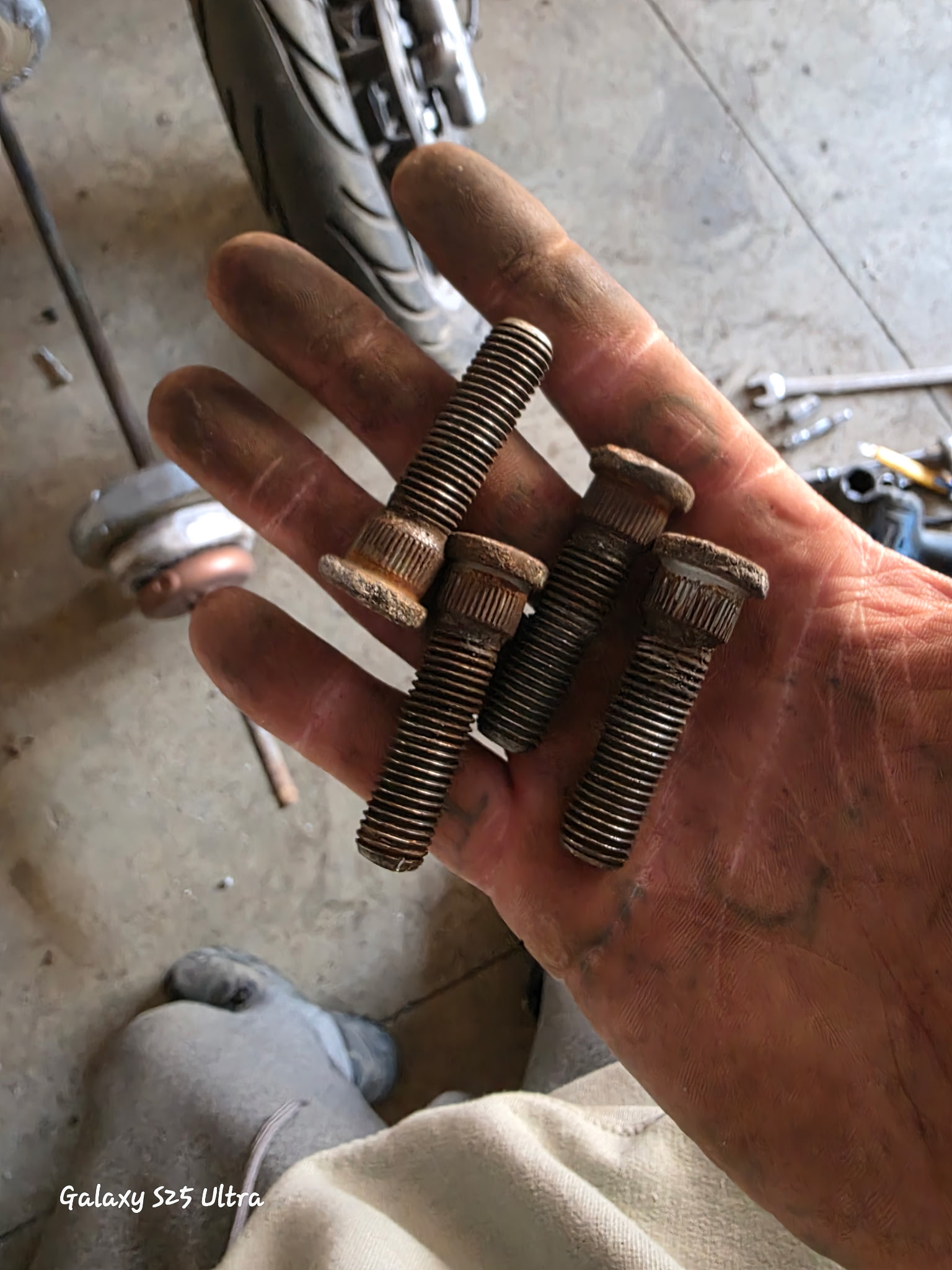 Andrew holding new wheel studs, ready to install